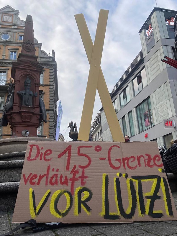 Großes X mit Plakat: "Die 1,5°-Grenze verläuft vor Lütze"